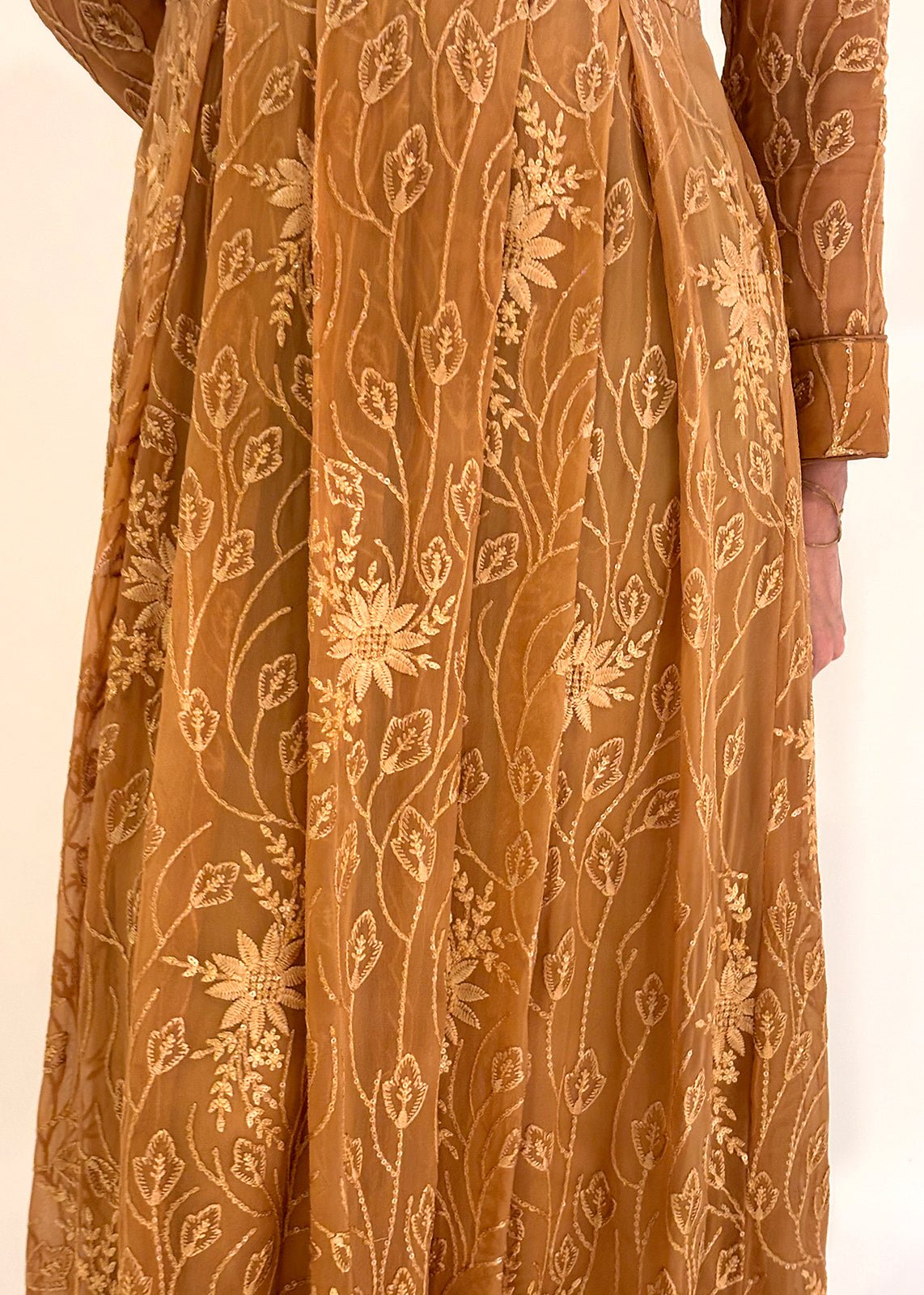 A woman wearing a brown ombre chiffon maxi dress with silk embroidery, in a standing pose against a neutral background.